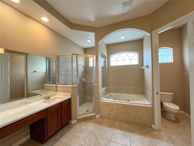 full bathroom with tile patterned flooring, a textured ceiling, toilet, and separate shower and tub