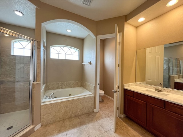 full bathroom featuring tile patterned flooring, a textured ceiling, toilet, vanity, and independent shower and bath