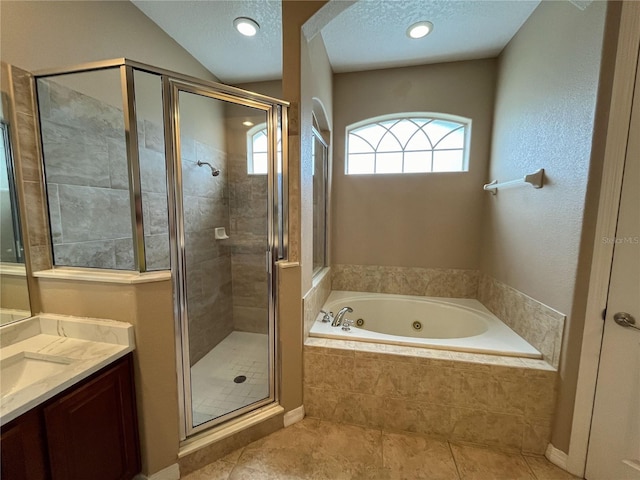 bathroom with tile patterned floors, vanity, shower with separate bathtub, and a textured ceiling