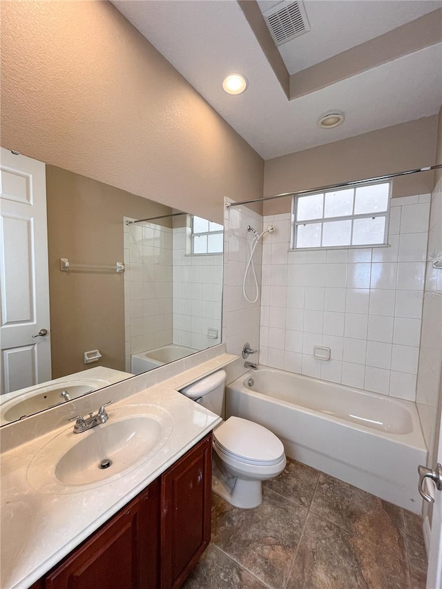 full bathroom featuring vanity, toilet, and tiled shower / bath combo