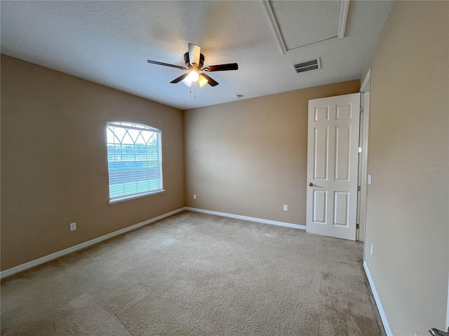 carpeted spare room featuring a textured ceiling and ceiling fan