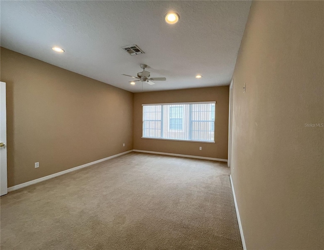 carpeted empty room with ceiling fan and a textured ceiling