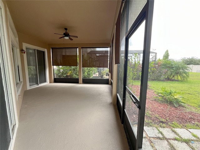 unfurnished sunroom featuring ceiling fan