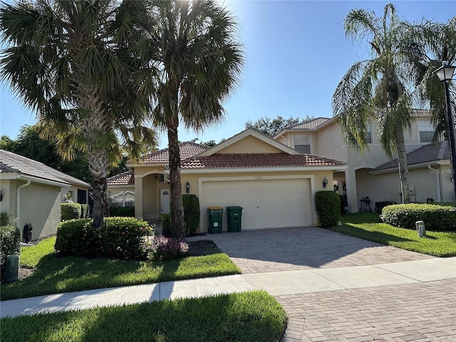 view of front of house featuring stucco siding, decorative driveway, an attached garage, and a tile roof