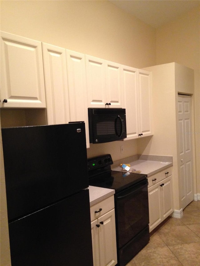 kitchen with black appliances, light tile patterned floors, and white cabinets