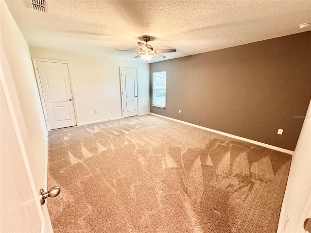 interior space featuring a textured ceiling, ceiling fan, and carpet