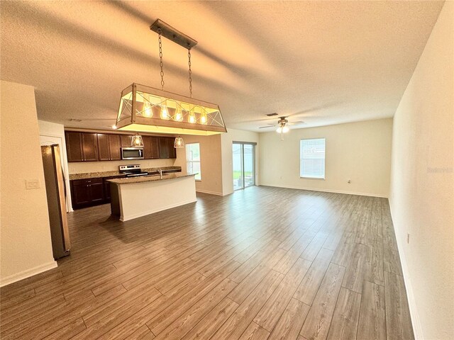 unfurnished living room with a textured ceiling, ceiling fan, and hardwood / wood-style floors