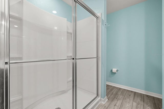 8 Slipper Flower Path E, Palm Coast, FL 32164 - bathroom featuring wood finished floors, a stall shower, and baseboards