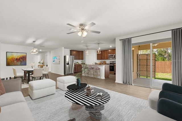 8 Slipper Flower Path E, Palm Coast, FL 32164 - living room with light wood-style floors, a ceiling fan, and baseboards