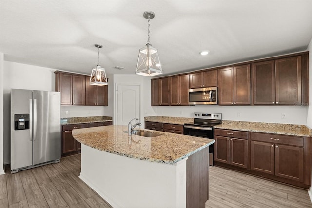 8 Slipper Flower Path E, Palm Coast, FL 32164 - kitchen with stainless steel appliances, a sink, light wood-style flooring, dark brown cabinetry, and light stone countertops