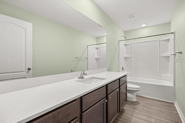 8 Slipper Flower Path E, Palm Coast, FL 32164 - bathroom featuring toilet, vanity, wood finished floors,  shower combination, and baseboards