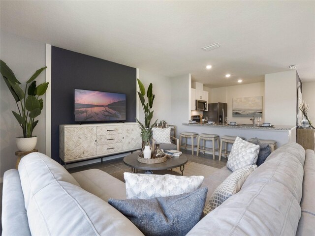 living room featuring tile patterned flooring and sink