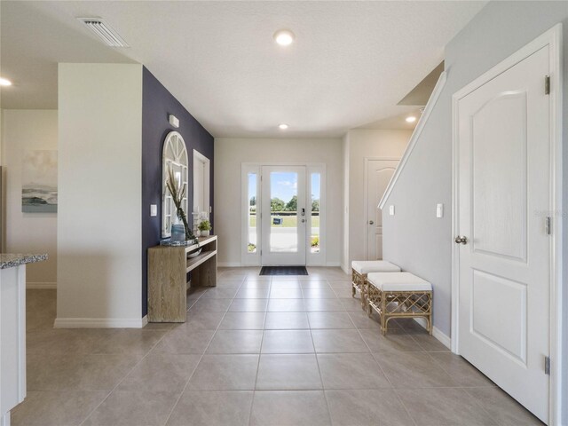 foyer entrance featuring light tile patterned flooring