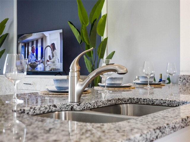 room details featuring light stone counters and sink