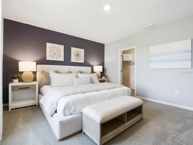 carpeted bedroom with a spacious closet and a closet