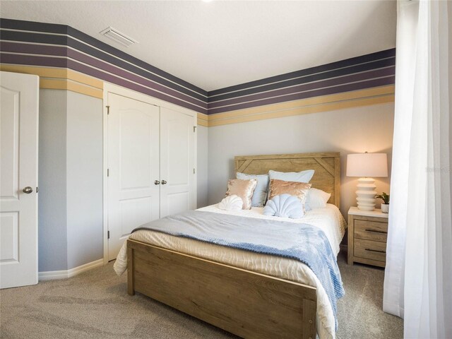 bedroom with light colored carpet and a closet