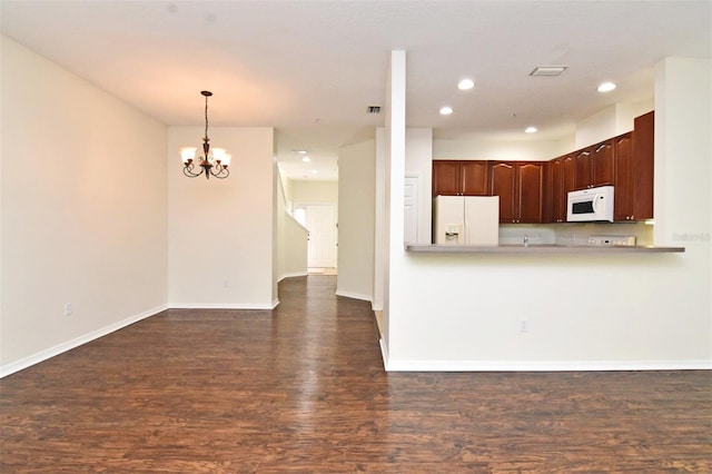 kitchen featuring dark wood-type flooring, white appliances, and an inviting chandelier