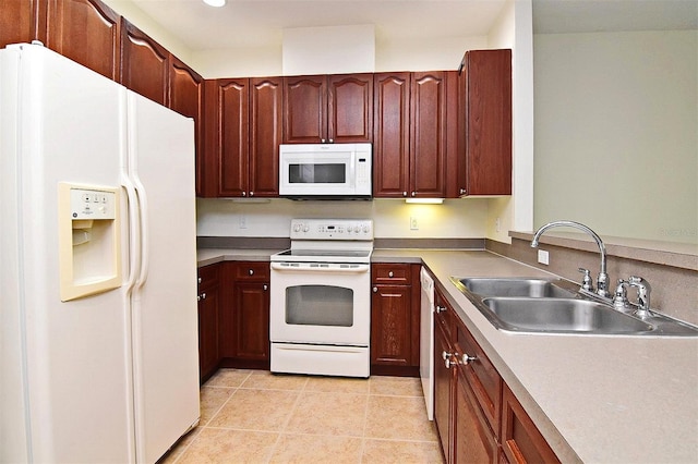 kitchen with sink, light tile patterned floors, and white appliances