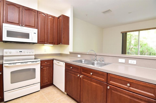 kitchen with sink, white appliances, and light tile patterned flooring