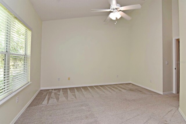 unfurnished room with light colored carpet and ceiling fan