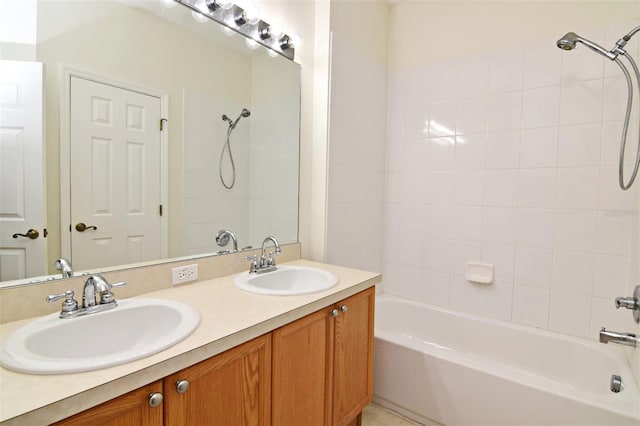 bathroom with tiled shower / bath combo and vanity