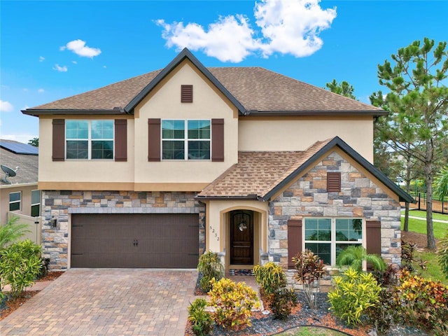 view of front facade featuring a garage, decorative driveway, roof with shingles, and stucco siding