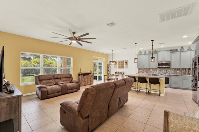 living room featuring light tile patterned floors, ceiling fan, visible vents, and recessed lighting