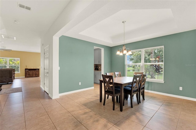 dining area featuring light tile patterned floors, a raised ceiling, visible vents, and an inviting chandelier