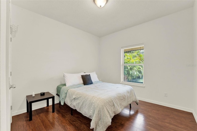 bedroom with wood finished floors and baseboards