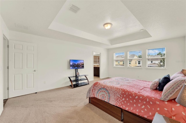 bedroom featuring baseboards, visible vents, a raised ceiling, light colored carpet, and a textured ceiling