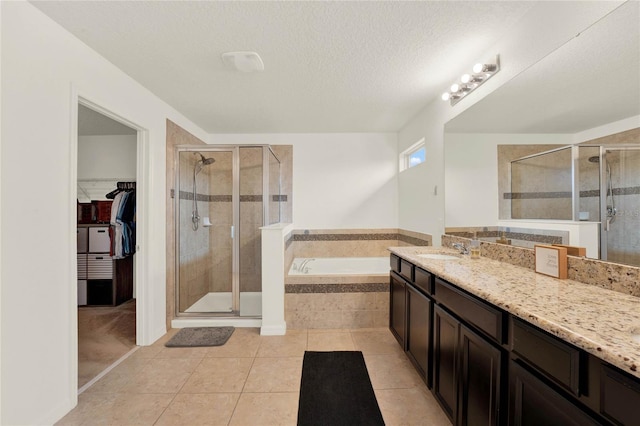 bathroom with a stall shower, a walk in closet, a garden tub, and vanity