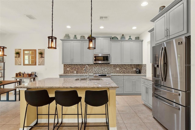 kitchen featuring appliances with stainless steel finishes, visible vents, a sink, and light tile patterned flooring