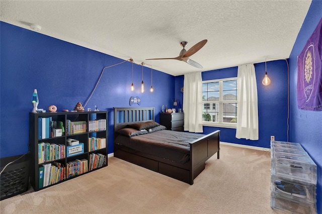 carpeted bedroom with a ceiling fan, a textured ceiling, and baseboards