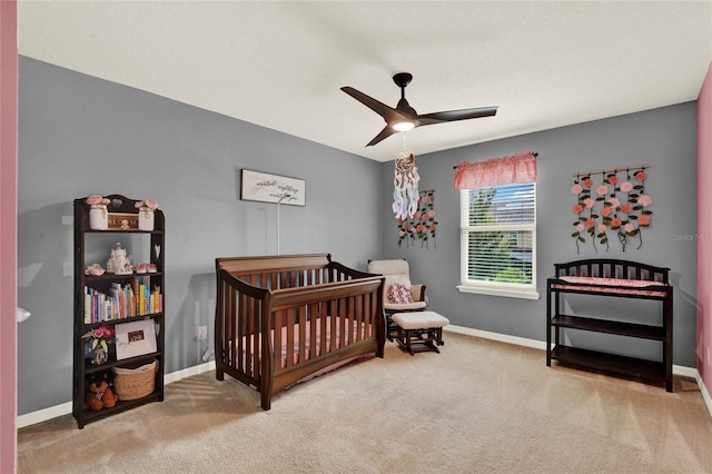 bedroom featuring a nursery area, carpet, and baseboards