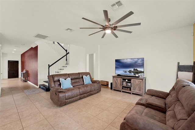 living area featuring light tile patterned floors, visible vents, and stairs