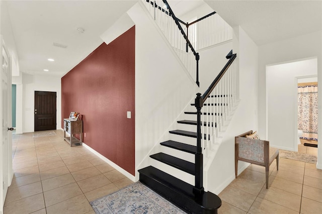 staircase with recessed lighting, baseboards, and tile patterned floors