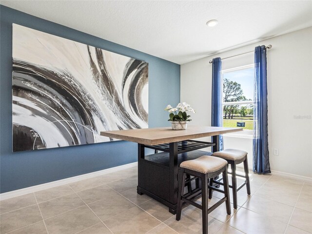 tiled dining area featuring a textured ceiling