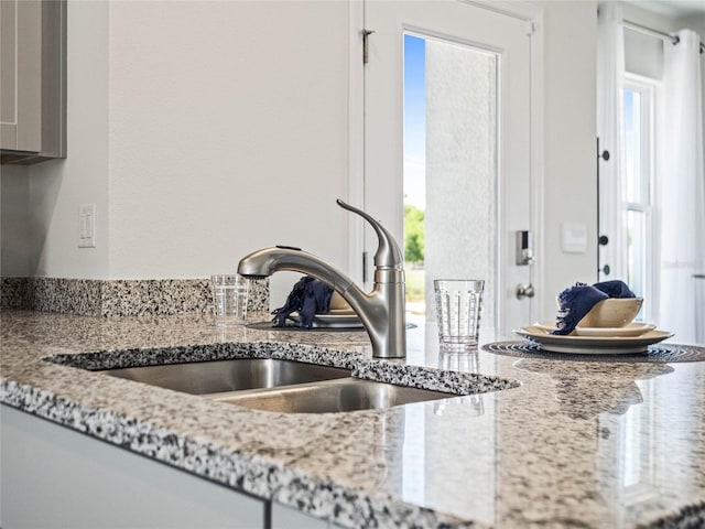 details featuring light stone counters and sink