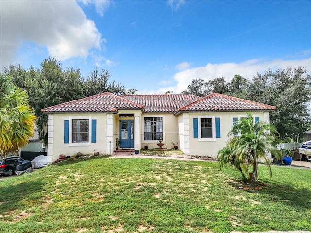 mediterranean / spanish-style house featuring a front lawn