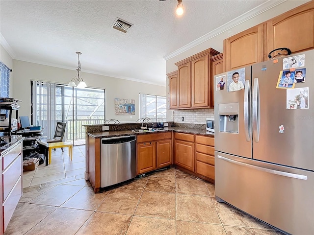 kitchen featuring pendant lighting, a textured ceiling, backsplash, stainless steel appliances, and crown molding