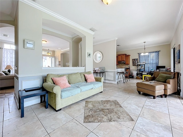 tiled living room with crown molding and a chandelier