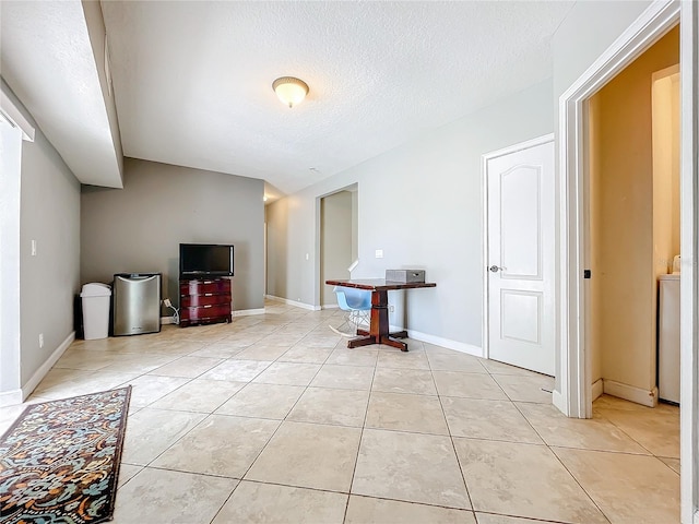 interior space with a textured ceiling and light tile patterned floors