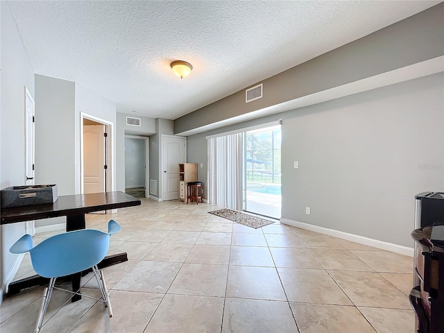 interior space with a textured ceiling and light tile patterned floors