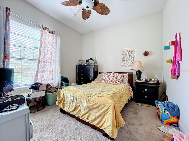 carpeted bedroom featuring ceiling fan and multiple windows