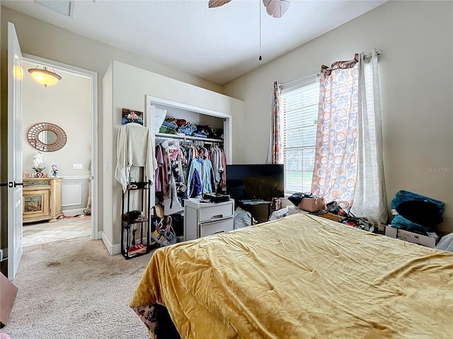 bedroom featuring ceiling fan, light colored carpet, and a closet