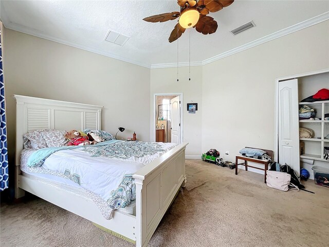 bedroom featuring ceiling fan, light colored carpet, a textured ceiling, and ornamental molding