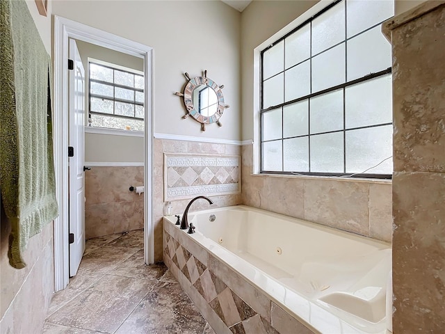 bathroom featuring tiled bath and tile walls