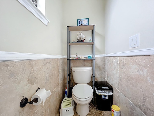 bathroom with tile walls, tile patterned flooring, and toilet