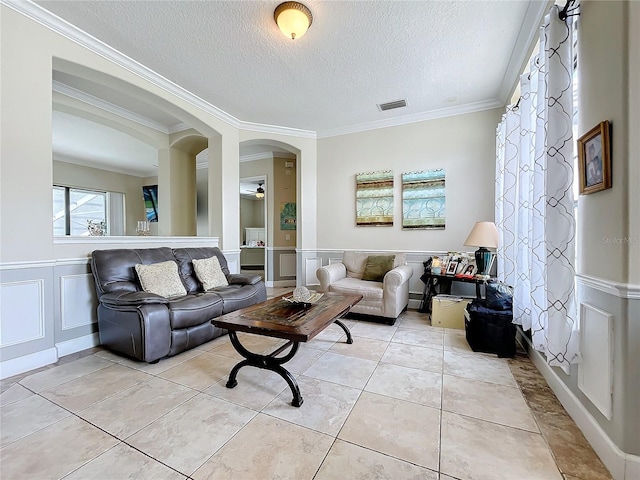 tiled living room with a textured ceiling and crown molding