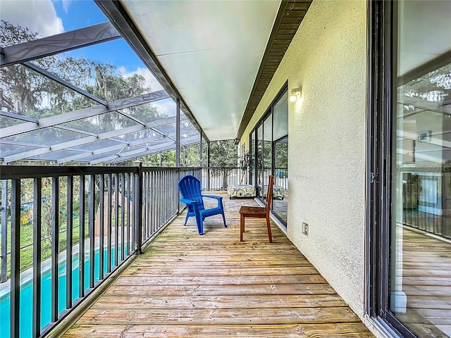 wooden deck with a lanai and a pool